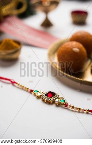 Indian Festival Raksha Bandhan With Rakhi Bracelets, Presents, Rice And Kumkum And Sweets In Plate
