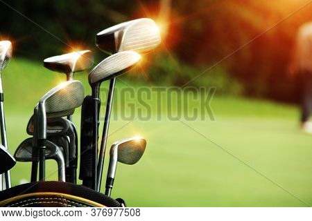Golf Equipment In Beautiful Golf Course At Sunset Background.