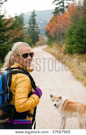 Woman Hiking In Mountains With Akita Dog