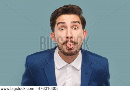 Portrait Of Funny Handsome Man With Mustache Standing Sticking Tongue Out, Showing Childish Behavior