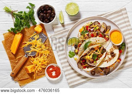 Grilled Steak Tacos With Olives, Tomatoes, Red Onion, Avocado, Cilantro, Corn, Shredded Cheddar Chee
