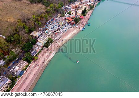 Aerial Drone Shot Of Blue Water Of River Ganga Stretching Into Distance With Steps Stairs On The Gha