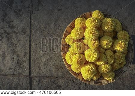 Fresh Marigold Flowers Bunch In Wicker Basket On Floor Background With Blank Space