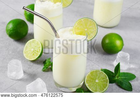 Brazilian Lemonade, Refreshing Creamy Lemonade Or Limeade With Lime Slices And Mint On Grey Backgrou