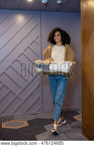 Cute Young Woman Carrying Clothes On The Way To Her Room In The Hotel