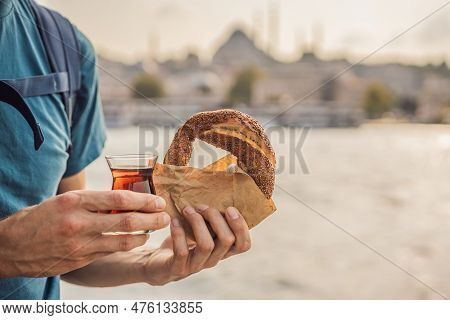 Man In Istanbul Having Breakfast With Simit And A Glass Of Turkish Tea. Glass Of Turkish Tea And Bag