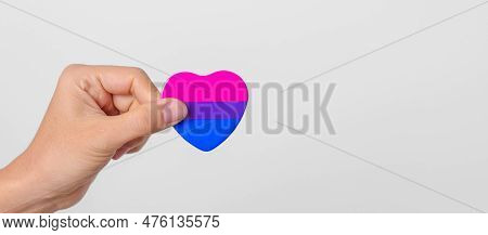 Bisexuality Celebrate Day And Lgbt Pride Month,  Lgbtq+ Or Lgbtqia+ Concept. Hand Holding Purple, Pi