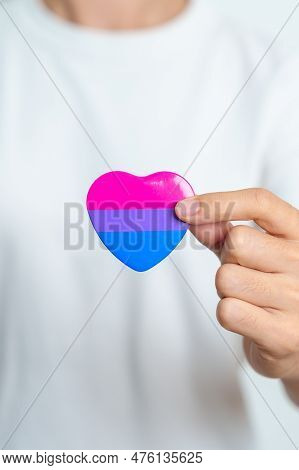 Bisexuality Celebrate Day And Lgbt Pride Month,  Lgbtq+ Or Lgbtqia+ Concept. Hand Holding Purple, Pi