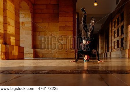 Teenager Boy Dancing Breakdance On A Tiled Floor In The Street. Youth Culture And Hip-hop Culture