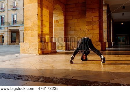 Teenager Boy Dancing Breakdance On A Tiled Floor In The Street. Youth Culture And Hip-hop Culture