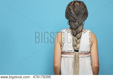 Woman With Long African Braids On Blue Background, Back View. Space For Text
