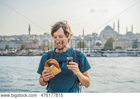 Man In Istanbul Having Breakfast With Simit And A Glass Of Turkish Tea. Glass Of Turkish Tea And Bag