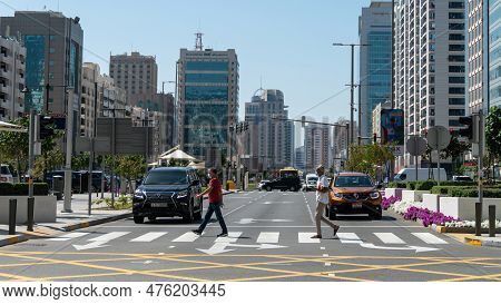 Abu Dhabi, United Arab Emirates - February 2022: People Wallking In A Crosswalk In Abu Dhabi City Wi