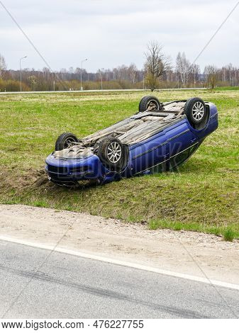 Car Accident Scene, A Passenger Car Left The Road And Overturned With Its Wheels Up, Overturned Car