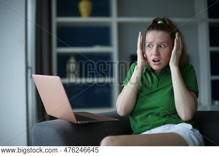 Young Unhappy Scared Dissatisfied Woman Customer Use Laptop Computer At Home In Living Room, Do Not 