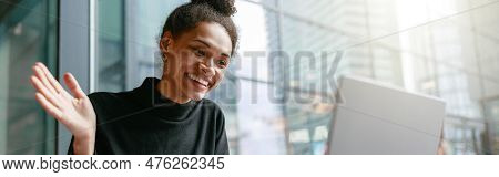 Smiling Woman Freelance Talking With Client Via Video Call And Waving Hi Sitting In Cafe