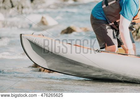 Happy Couple Kayaks In An Inflatable Kayak On The Sea At Sunset. Couple Kanoeing In The Sea Near The