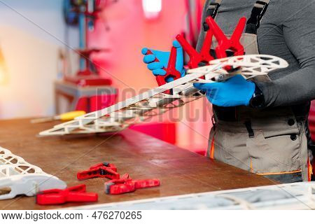 Close-up Image Of Young Male Engineer Or Technician Working On Drone Details In Lab. Plane Wing.
