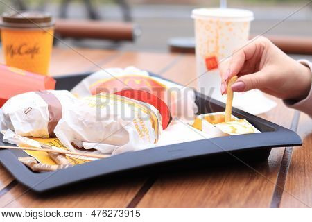 Kyiv, Ukraine - May 11, 2023: The Girl Eats At Mcdonald\'s At An Open-air Table. The Girl Eats Fast 