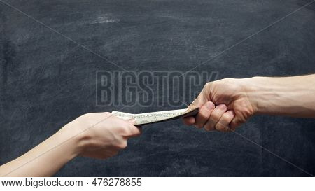Money Exchange. Foreign Currency. Female And Male Hands Holding Dollars On Black Chalkboard Backgrou