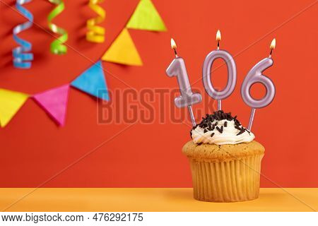 Birthday Cake With Number 106 Candle - Sparkling Orange Background With Bunting