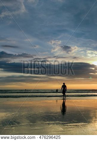 Silhouette Of A Woman On The Beach Enjoying The Sunset At Seminyak Beach.