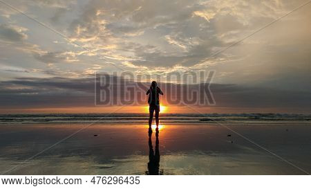 Silhouette Of A Woman On The Beach Enjoying The Sunset At Seminyak Beach.