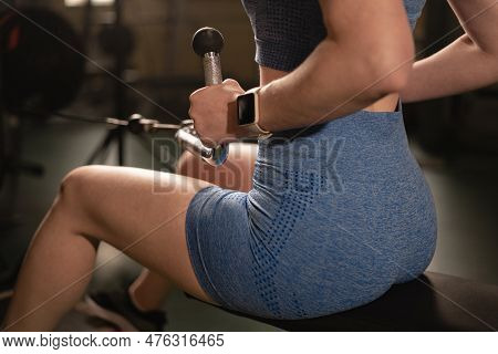 Strong Woman Sitting While Rowing At The Cable Machine For Back Muscles, Intense Workout At The Gym.