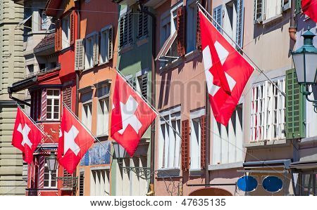 Gamle gade Augustinergasse i Zürich dekoreret med schweiziske flag
