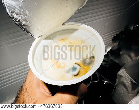 A Closeup Of A Person Holding An Unhealthy Breakfast Joghurt Plate, With Mold-covered Food On It