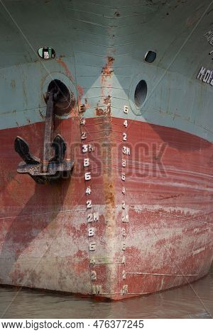 Large Ship Front Close Up Shot On A Riverbank. Rusty Anchor Hanging On The Ship. Old Ship Front With