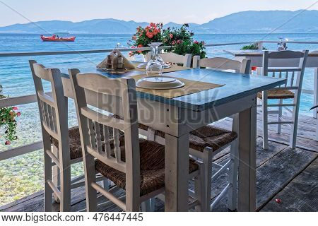 A Captivating View Of An Empty Tavern Restaurant By The Picturesque Seafront, Featuring Inviting Woo
