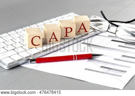 Capa Written On Wooden Cube On The Keyboard With Chart On Grey Background