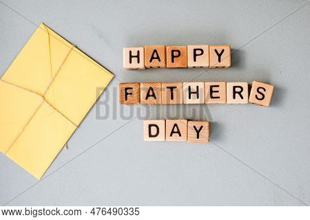 Happy Fathers Day Concept. Background, Congratulatory Card. Wooden Cubes With Black Letters Are Laid