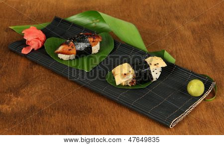 Velsmagende Maki sushi - Roll på måtten på brune baggrund