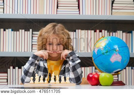 Child Play Chess At School. Child Think About Chess Game. Intelligent, Smart And Clever School Kid P