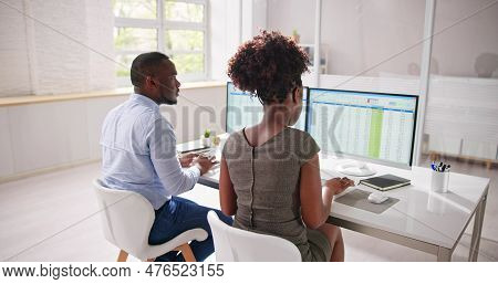Analyst Employee Working On Spreadsheet Using Desktop Computer