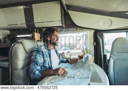 Travel With Vehicle Camper Concept People Lifestyle. One Man Smiling And Choosing On Road Map Next D
