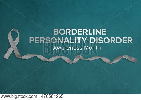 Photo Of Gray Ribbon With Curled End Atop A Concrete Background For Borderline Personality Disorder 