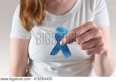 Young Caucasian Woman Holding A Blue Awareness Ribbon For Prostate Cancer Awareness Month.