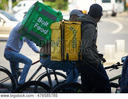 Bucharest, Romania - 2st May, 2023: Two Bolt Food And Glovo Food Delivery Couriers, Workers Of Forei