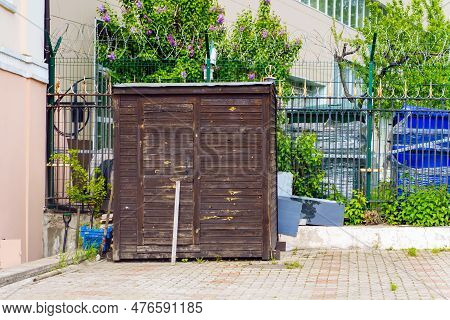 A Wooden Building Near The Building For Horseradish Cleaning Equipment. The Door Is Propped Up With 