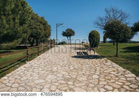 Beautiful Stone Pavement In Mountain Village With Neat Lawn And Trees. Sunny Day With Clear Sky In T