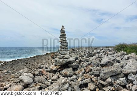 A Tall Tower Of Flat Stones Stands On The Seashore In Cloudy Weather. Stone Shore, Neatly Stacked St