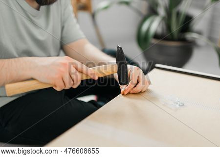 Young Attractive Man Assembles Furniture - Handwerker And Interior Objects Concept