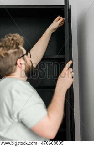 Young Attractive Man Assembles Furniture - Handwerker And Interior Objects Concept