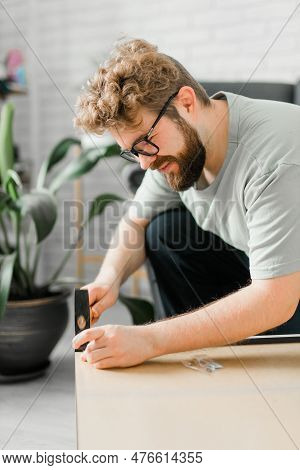 Young Attractive Man Assembles Furniture - Handwerker And Interior Objects Concept