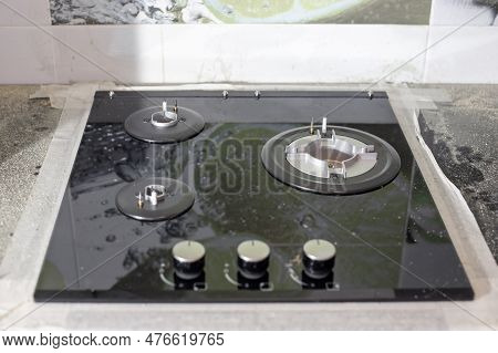 The Black Glass-ceramic Gas Hob Is Built Into The Kitchen Worktop. Installation Of A Built-in Stove.