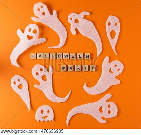 White Ghosts Craft For Halloween Party. Wrapping Paper Ghost On Orange Background Top View. Cartoon 