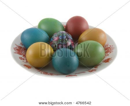 The Easter Decorated Eggs Lying In White Porcelain Plate With A Red Ornament